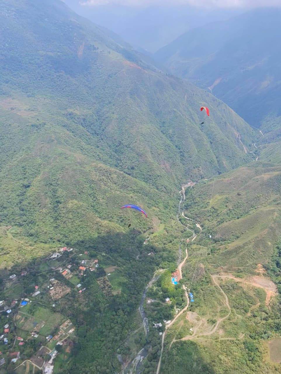 Paragliders over the foothills near Piedechinche